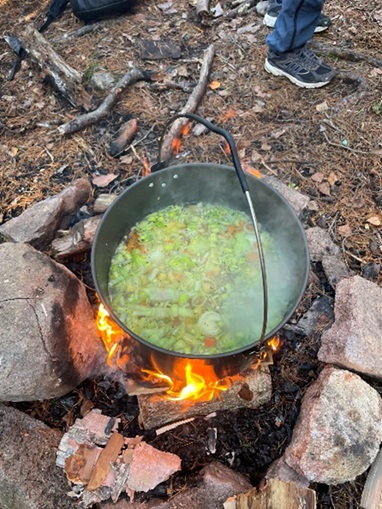 Suppen koker i kjelen over bålet