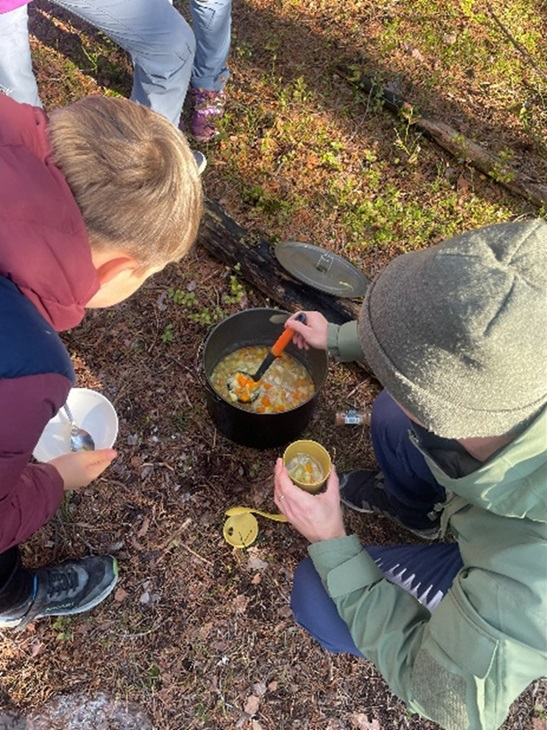 To elever som forsyner seg av grønnsakssuppe